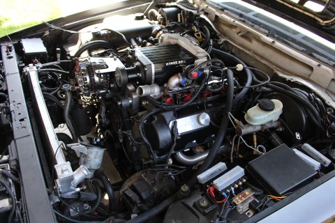 2003 Ford Crown Victoria - Engine bay close-up showing a Kenne Bell supercharger, chrome alternator, brake master cylinder reservoir and ABS module.