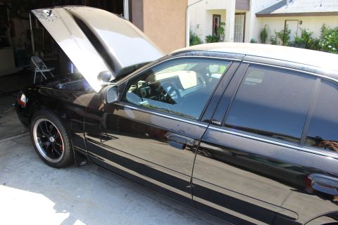 2003 Ford Crown Victoria - Front-side view of a black sedan with hood raised; a small VIPER decal is visible on the rear door window.