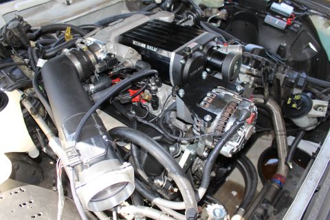 2003 Ford Crown Victoria - V8 engine bay fitted with a black Kenne Bell supercharger above a chrome alternator and serpentine pulley system.