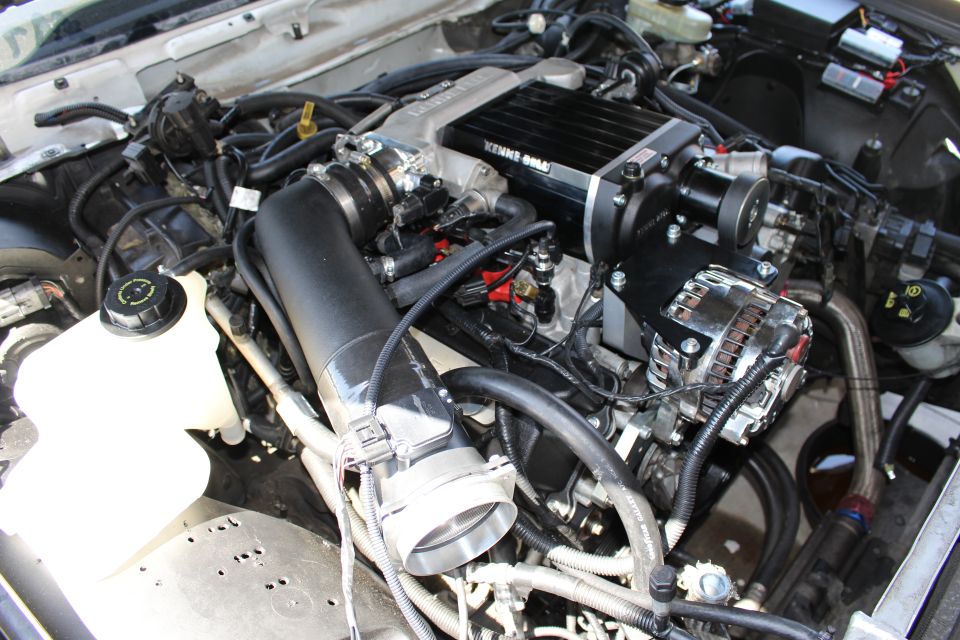 Engine bay close-up of a Kenne Bell supercharger and chrome alternator on a V8