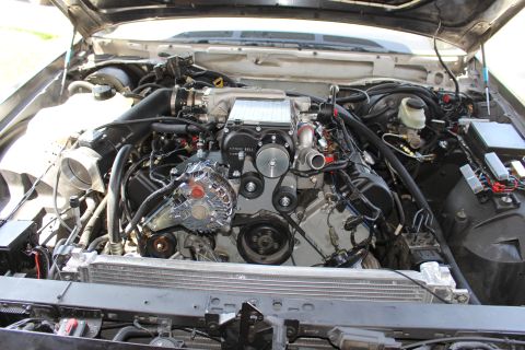 2003 Ford Crown Victoria - Front-on engine-bay view of a V8 with a black Kenne Bell supercharger, chrome alternator and aluminum radiator.
