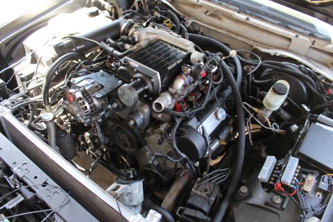 2003 Ford Crown Victoria - engine bay showing a Kenne Bell supercharger atop the intake, a chrome alternator, brake master cylinder and routed wiring.