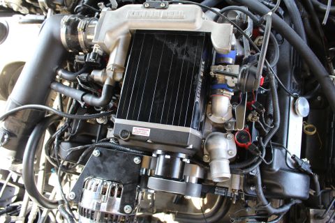 2003 Ford Crown Victoria - close view of a Kenne Bell supercharger showing its black finned intercooler core and a warning decal.