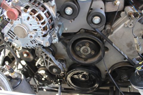 2003 Ford Crown Victoria - front accessory drive showing a chrome alternator, crankshaft pulley, idler pulleys and serpentine belt.