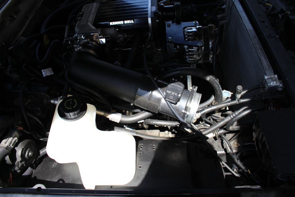 Black intake pipe with mass airflow sensor and coolant reservoir