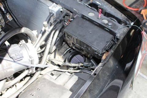 2003 Ford Crown Victoria - blue-and-black cone air filter and a black fuse box tucked into the corner of an engine bay.