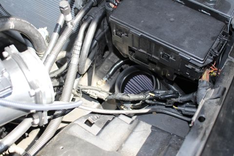 2003 Ford Crown Victoria - conical air filter sits beside a black fuse box and bundled wiring harness inside the engine bay.
