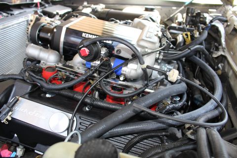 2003 Ford Crown Victoria - Engine close-up showing a black Kenne Bell supercharger above a Trick Flow valve cover, red coil packs and braided lines.