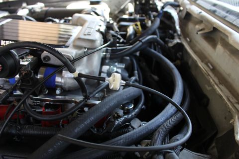 2003 Ford Crown Victoria - Angled engine bay view of a Kenne Bell supercharger surrounded by bundled black hoses, blue couplers and red coil packs.