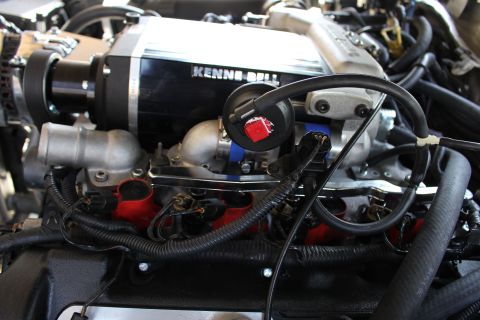 2003 Ford Crown Victoria - Close-up of a polished Kenne Bell supercharger mounted on an engine with red valve covers and a blue throttle coupler.