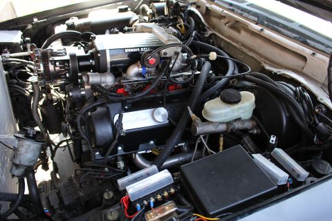 2003 Ford Crown Victoria - Engine compartment featuring a Kenne Bell supercharger, finned oil-fill cap, brake master cylinder and a fuse box at lower right.