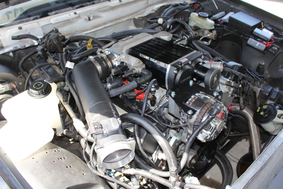Engine bay with chrome alternator, intake tube and supercharger