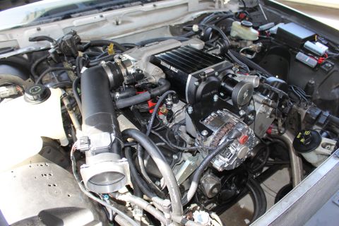 2003 Ford Crown Victoria - Engine compartment with a Kenne Bell supercharger, prominent chrome alternator and large black intake tube on the left.