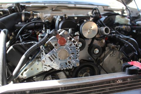 2003 Ford Crown Victoria - Detailed close-up of a polished chrome alternator and Kenne Bell supercharger drive pulleys with serpentine belt and red tow hook.