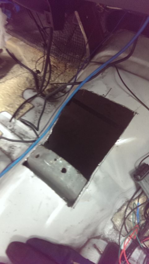 2000 Mercury Grand Marquis - The interior floor of a vehicle shows a large cut-out and exposed wiring, suggesting modifications.