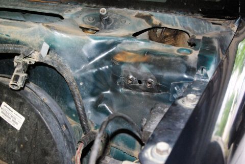 1995 Ford Bronco - Close-up of a vehicle's engine bay, showing the strut tower and associated wiring, with a visible part number label.
