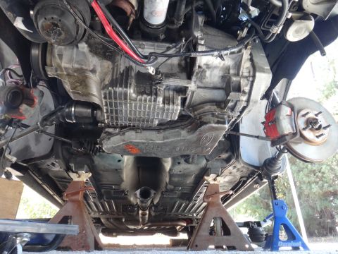 1993 Ford Taurus - Car's underside on jack stands, revealing the engine, transmission, and suspension parts.