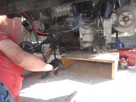 1993 Ford Taurus - Mechanic working on vehicle transmission and suspension components.