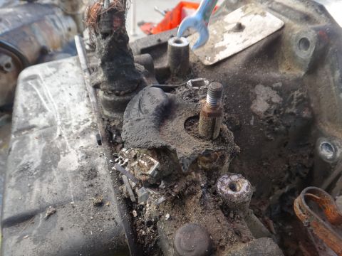 1993 Ford Taurus - A close-up view of a heavily soiled mechanical part, possibly from a vehicle's engine, with exposed wiring and a wrench in the background.