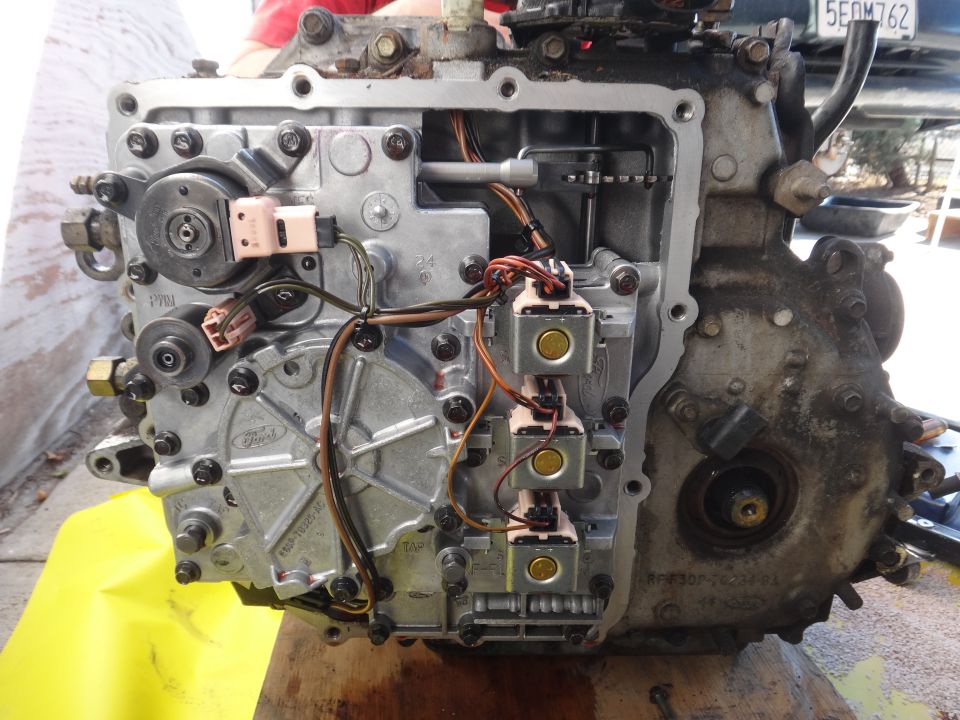 Close-up of a Ford transmission valve body with electrical connectors and solenoids