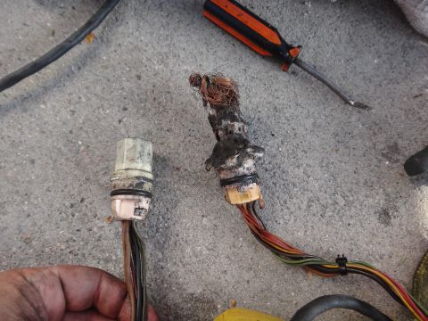 1993 Ford Taurus - Damaged electrical connectors and wiring, possibly from a vehicle repair or maintenance task.