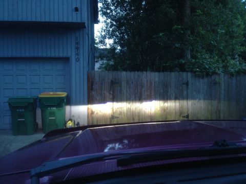 1992 Ford F-150 - Headlights from a 1992 Ford F-150 illuminate a wooden fence and two trash cans in front of a garage.