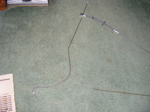Brake line and vacuum hose laid out on carpet next to a vent