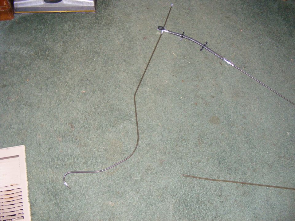 Brake line and vacuum hose laid out on carpet next to a vent