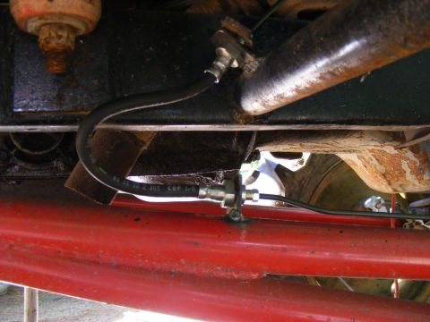 Close-up of a brake line on a red vehicle frame