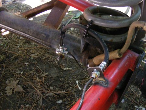 Rear axle brake line assembly with coil spring and red frame component