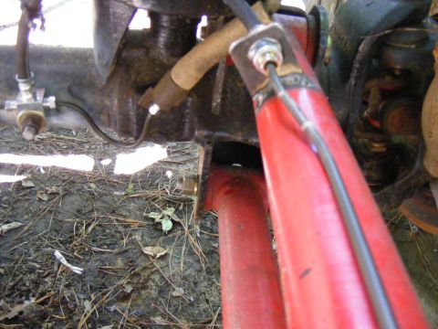 Close-up of red suspension part and brake line attached to black metal