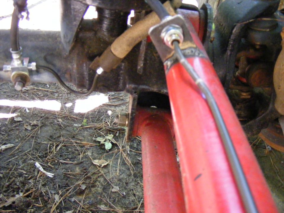 Close-up of red suspension part and brake line attached to black metal