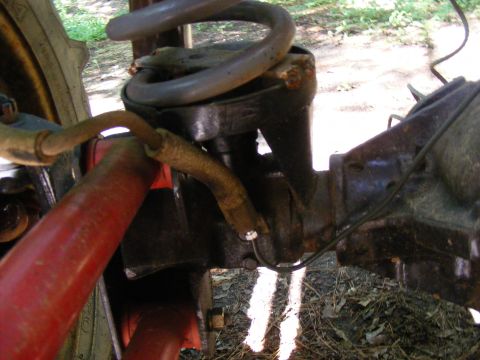 Close-up of a vehicle's rear suspension and differential assembly, showing a coil spring and brake lines