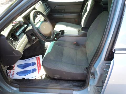 2001 Ford Crown Victoria - The interior of a police car is shown, with a focus on the driver's seat and dashboard area.