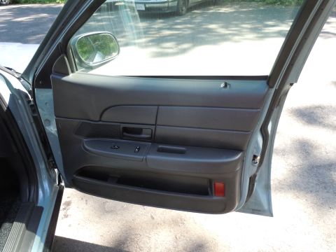 2001 Ford Crown Victoria - Interior door panel detail of a car, showing window controls and storage compartment.