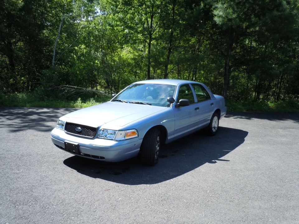 2001 Ford Crown Victoria parked on asphalt with trees in background