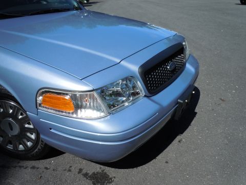 2001 Ford Crown Victoria - The front end of a blue 2001 Ford Crown Victoria is shown parked on asphalt.