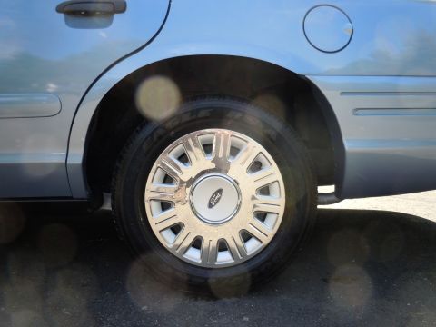 2001 Ford Crown Victoria - Close-up of the rear wheel and fender of a light blue 2001 Ford Crown Victoria.