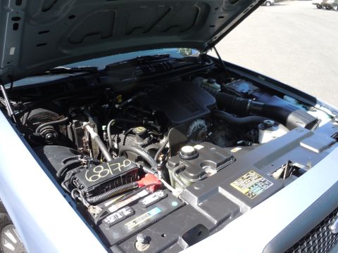 2001 Ford Crown Victoria - The engine bay of a car, showing the engine, battery, and fuse box with handwritten markings.