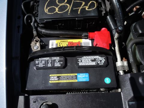 2001 Ford Crown Victoria - Close-up of a car battery in the engine bay, with "68/70" handwritten on a nearby component.
