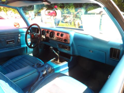 1971 Ford Ranchero - The bright blue interior of a classic Pontiac Firebird Trans Am features a wood-grain dash and plush seating.