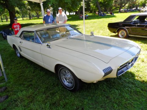 1971 Ford Ranchero - This customized classic car, likely a 1965 model, is displayed outdoors with other vehicles and people in the background.
