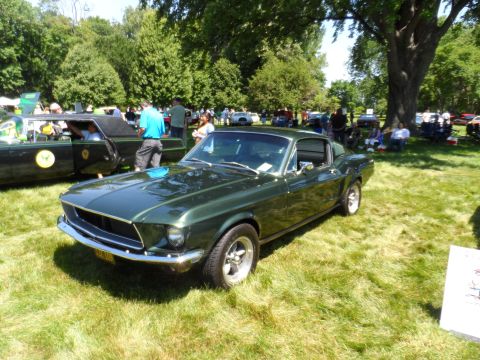 1971 Ford Ranchero - A green coupe, likely a 1968 model, is displayed on a grassy field with other vehicles and people in the background.