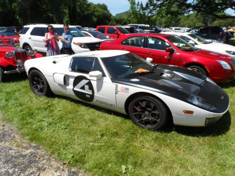 1971 Ford Ranchero - A white Ford GT race car with a black hood and the number 4 on its side is parked on a grassy field.
