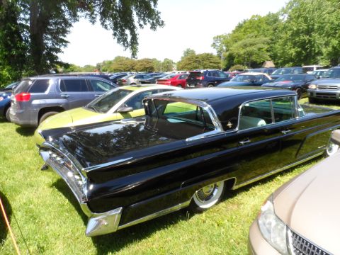 1971 Ford Ranchero - A black vintage Lincoln Continental is parked on grass with many other vehicles in the background.