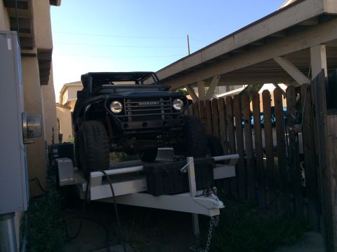 1968 Ford Mustang - A black Suzuki Samurai is loaded onto a trailer, viewed from the front with off-road modifications.