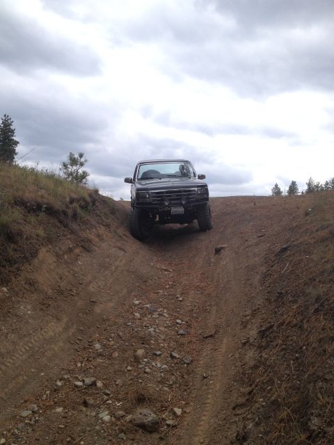 2005 Jeep Wrangler - Off-road vehicle navigating a challenging dirt path on an overcast day.