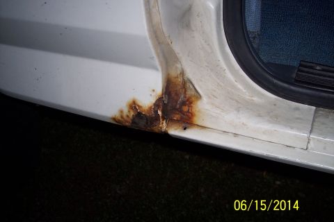 1990 Ford Bronco - Rust is visible on the door sill of a white vehicle, indicating potential body damage.