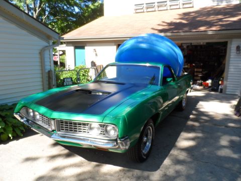 1971 Ford Ranchero - A green pickup truck is parked in a driveway with a large blue inflatable object in its bed.