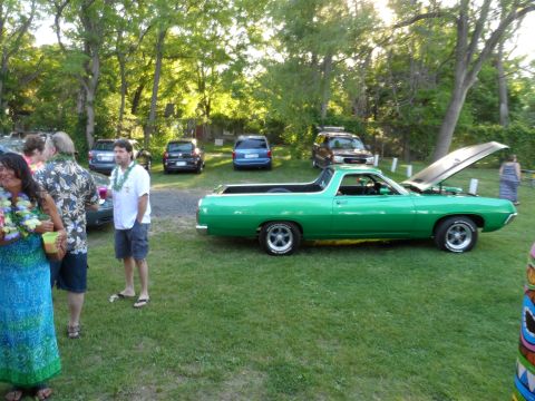 1971 Ford Ranchero - A green pickup truck is parked on a grassy lawn with people and other vehicles around.